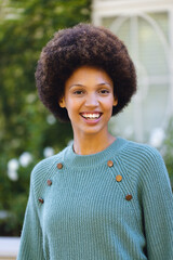 Fototapeta premium Portrait of happy african american woman looking at camera and smiling in garden