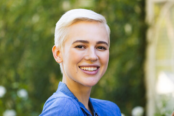 Portrait of happy caucasian woman looking at camera and smiling in garden