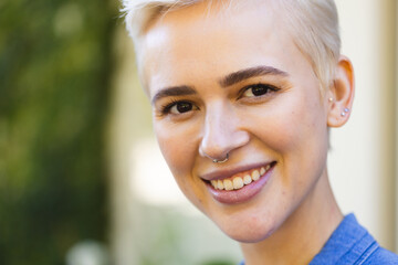 Portrait of happy caucasian woman looking at camera and smiling in garden