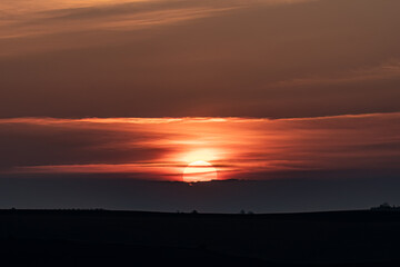 Fototapeta na wymiar Sun hiding behind the clouds during sunset