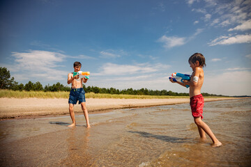 couple of children playing on the beach with water