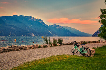 View of the beautiful Lake Garda surrounded by mountains, Scenic view of sunset at Lake Garda in the evening with the beautiful sunset colors, italy