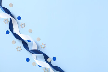Blue and white ribbons with confetti on blue table. Israel Independence Day, Yom Haatzmaut greeting...