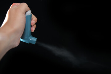 Close up of Asthma inhaler spray on black background