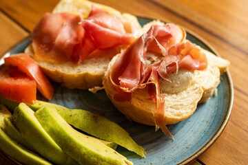 Poached eggs with bacon, artisan bread, avocado and tomato.