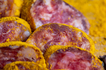Sliced pork salami with spices and lots of turmeric