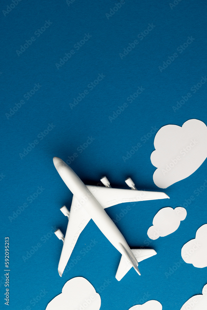 Poster close up of airplane model with clouds on blue background with copy space