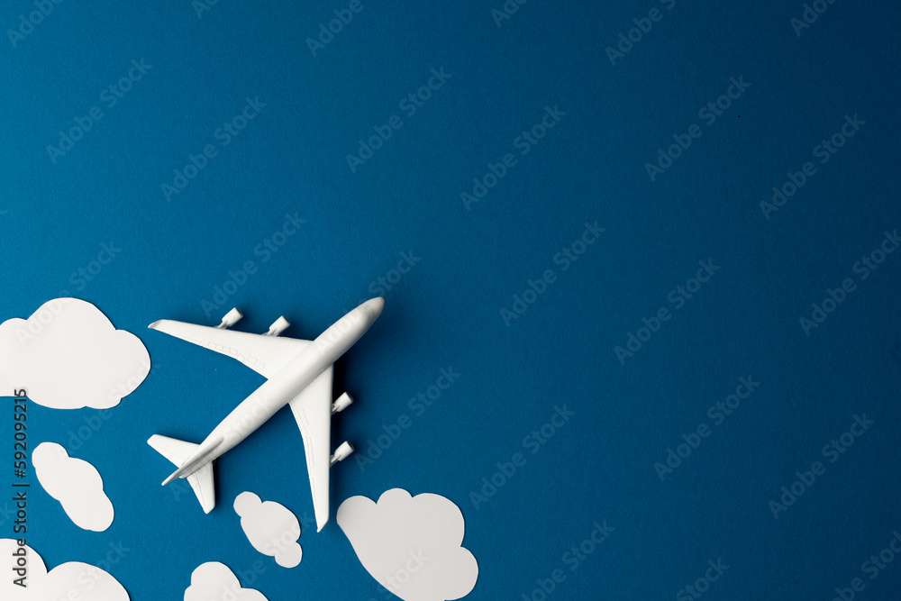 Poster close up of airplane model with clouds on blue background with copy space