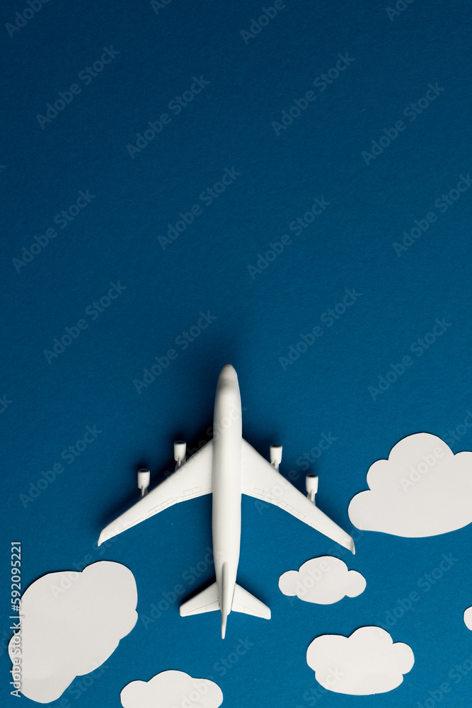 Poster close up of airplane model with clouds on blue background with copy space