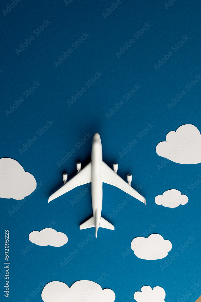 Poster close up of airplane model with clouds on blue background with copy space