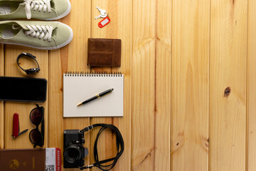 Fototapeta premium Close up of travel equipment with smartphone on wooden background with copy space