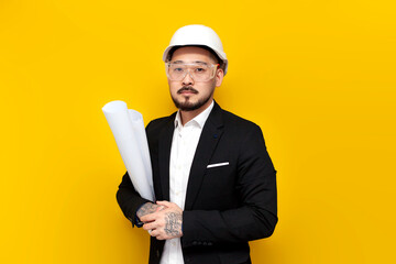 asian foreman in black suit with papers and projects on yellow isolated background, korean civil engineer in hardhat