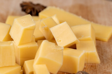 Yellow hard cheese sliced on a board