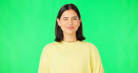 Fototapeta premium Happy, woman and face wink on green screen, studio and color background. Portrait, female model and winking with smile of cool girl, fun mood and joyful personality in happiness, emoji and flirting