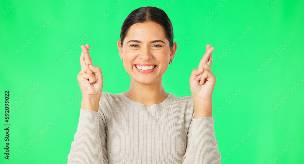 Canvas Prints Excited woman, fingers crossed and face on green screen, background and studio for good luck. Portrait of happy female model hope for winning prize, wish and optimism with emoji sign, hands and smile