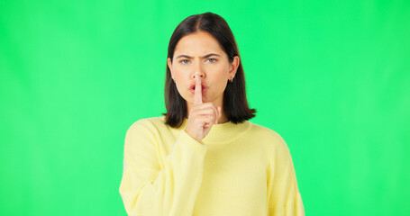 Secret, green screen and face of serious woman in studio, finger and lips on background for privacy. Portrait, angry female model and silence of noise, shush on mouth and quiet for confidential emoji