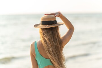 Beautiful woman in bikini on the beach enjoying her holiday and sea breeze
