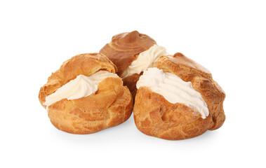 Delicious profiteroles with cream filling on white background