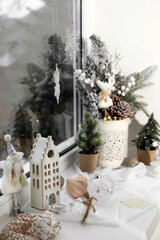 Beautiful Christmas decorations and small fir trees on window sill indoors