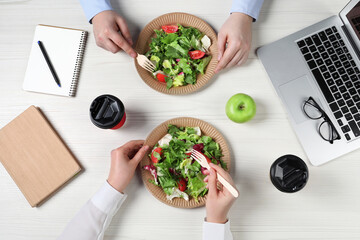 Office employees having business lunch at workplace, top view