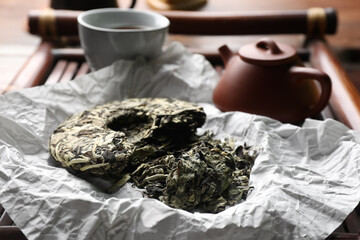 Fototapeta na wymiar Broken disc shaped pu-erh tea on tray, closeup. Traditional ceremony