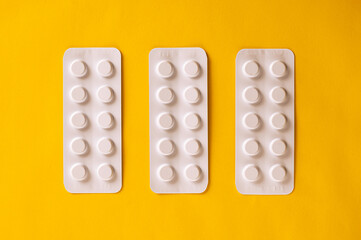 Pack of pills on yellow background. Top view
