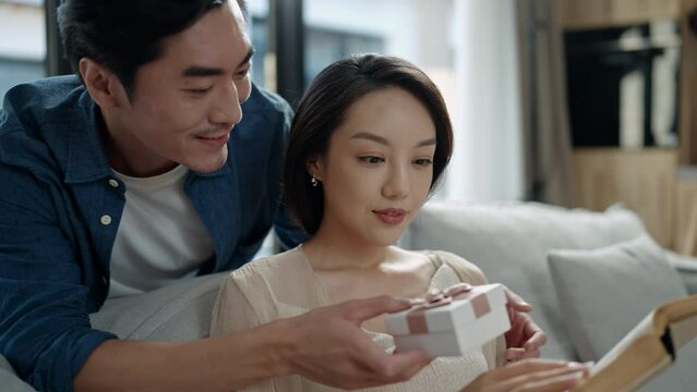 Happy young woman receiving gift from her husband,4K