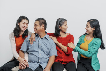 Happy anniversary day family of Elderly father and mother with old sister and young sister real people sitting together on sofa, Do activities together with love happily in the summer.