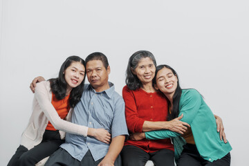 Hugging, Happy anniversary day family of Elderly father and mother with old sister and young sister real people sitting together on sofa, Do activities together with love happily in the summer.