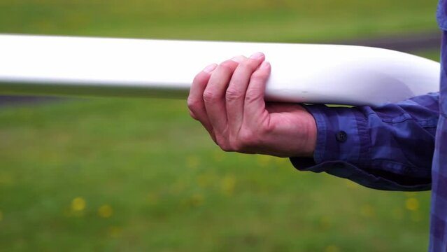 hand holding and wearing wing of a small airplane
