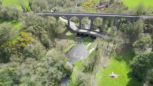 Viaduct over a Bridge Waterford Greenway Ireland cyclist pauses to take in the view of the river and road bridge below
