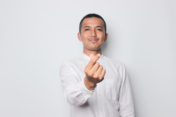 Smiling Asian young man wearing brown shirt with love hand symbol isolated on white background.