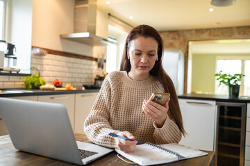 Young adult woman using her phone at home