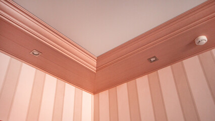 Part of the living room, corner of the wall from the ceiling, mounted LED lights in a wooden...