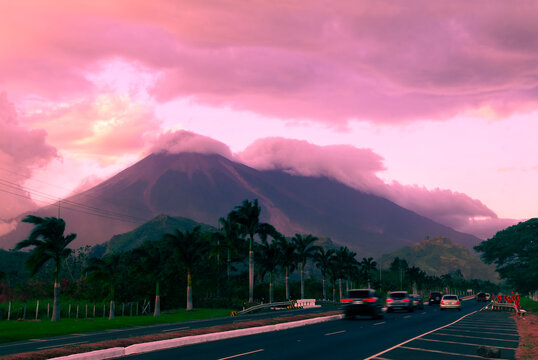 Palin Escuitla highway at sunset in Guatemala, Central America, passenger and cargo transport area, cloud covered volcanoes in the background.