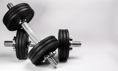 Metal dumbbells with black pancakes on a white background.
