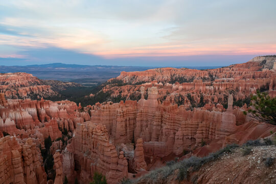 Aerial sunset view of massive hoodoo sandstone rock formation boat mesa in Bryce Canyon National Park, Utah, USA. Last sun rays touching on natural unique amphitheatre sculpted from red rock. Twilight