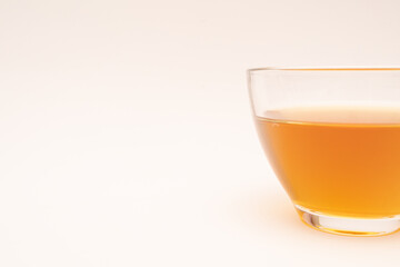 Glass cup of hot ginger tea isolated on white background.