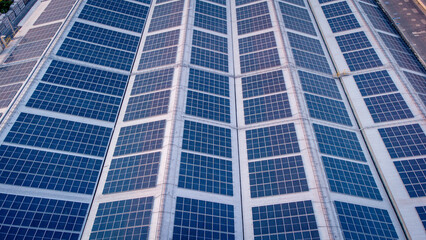 Fototapeta premium A large solar cell roof on an industrial building Generating electricity for the plant during daytime according to policies and measures to reduce global warming by taking high-angle shots from drones