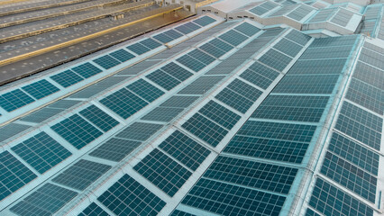 A large solar cell roof on an industrial building Generating electricity for the plant during daytime according to policies and measures to reduce global warming by taking high-angle shots from drones