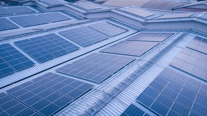 A large solar cell roof on an industrial building Generating electricity for the plant during daytime according to policies and measures to reduce global warming by taking high-angle shots from drones