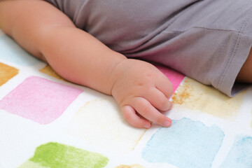 Close up portrait of baby hand in a bed