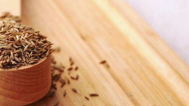 cumin seeds on spoon on table , close up 