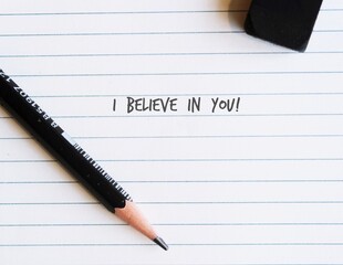 Pencil on note paper with handwritten text - I believe in you! - supporttive phrase to encourahe someone else or positive self talk affirmation