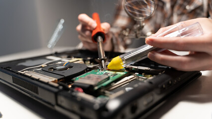 Naklejka premium the master solders the board with a soldering iron