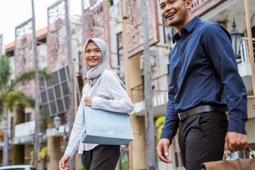 Muslim male and female workers going to work in office buildings