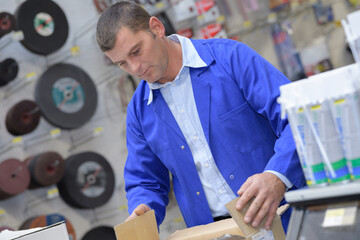 worker with choices engine oil in the supermarket