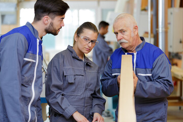 woodworker trainer teaching how to inspect evenness