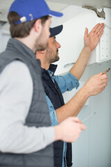 two carpenters work on assemble wardrobe