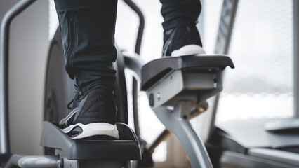 Obraz premium athlete on an elliptical simulator in the gym